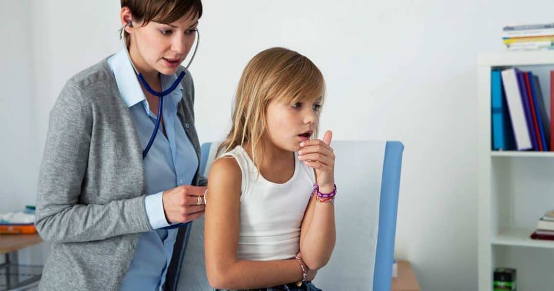 What is Severe Asthma? 5 A doctor listens to a young girl's breathing with a stethoscope. The girl is sitting on an examination table, wearing a white tank top and jeans, and appears to be coughing. The room is bright and contains shelves and a desk.